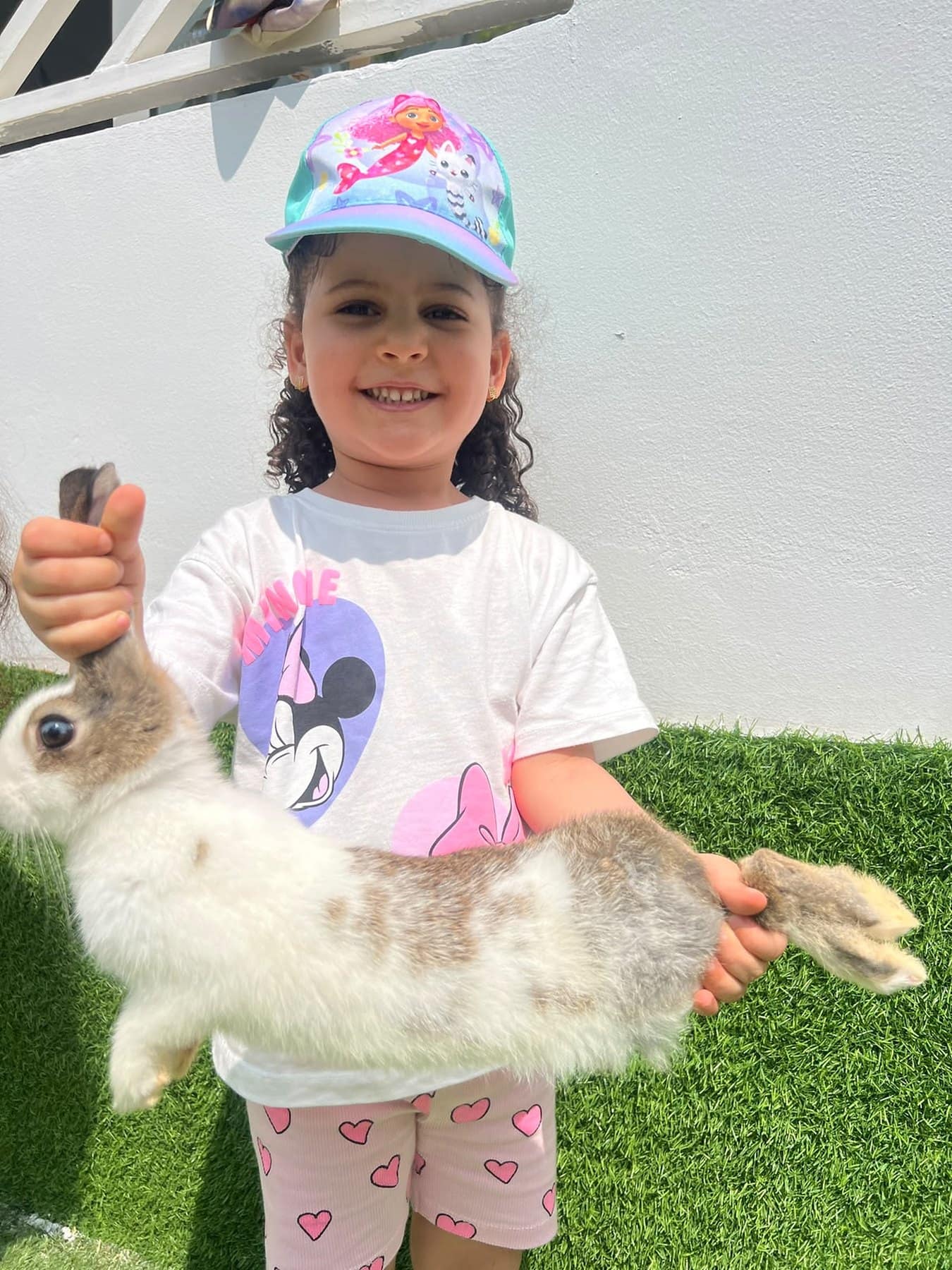 Des enfants caressent un lapin dans le jardin