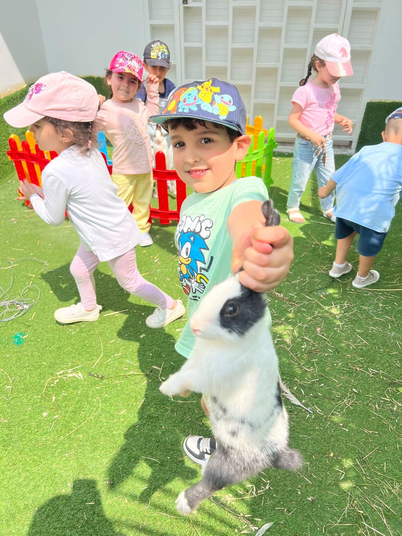 Une fillette tient un lapin dans le jardin de la crèche