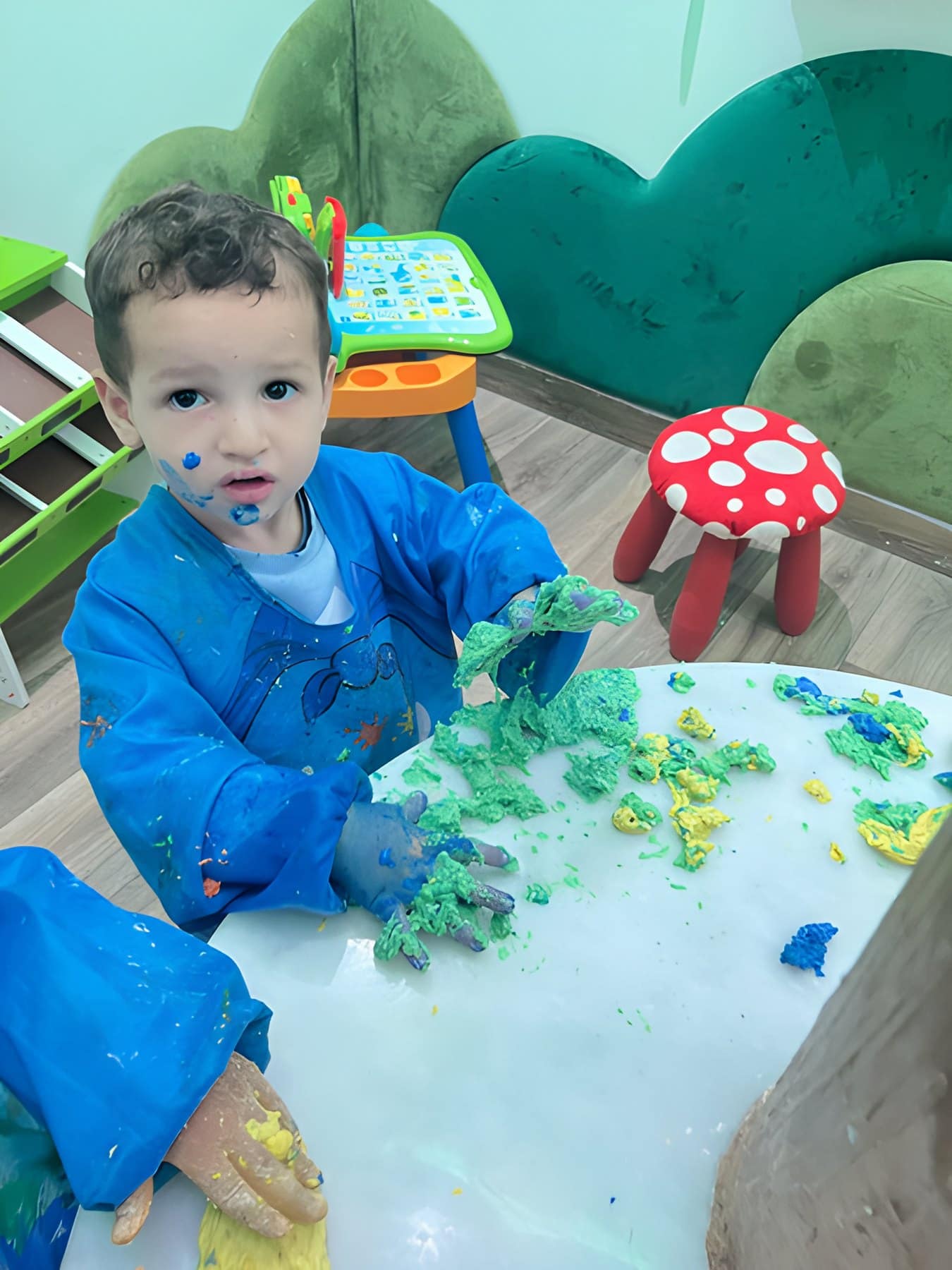 Un enfant concentré sur un atelier de pâte à modeler